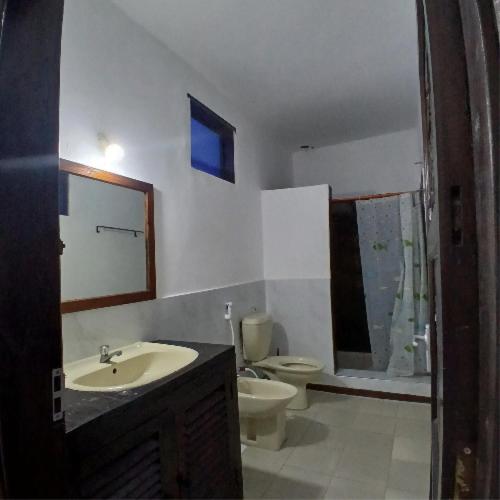 a bathroom with a sink and a toilet and a mirror at Tatia apartment in Malindi
