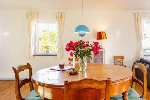 a dining room table with a vase of flowers on it at Zita Ferienhäuser - Ferienhaus Feni in Neckargemünd