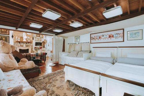 a living room with white furniture and a large teddy bear at Home Tower tree เชียงใหม่ in Pong Yaeng