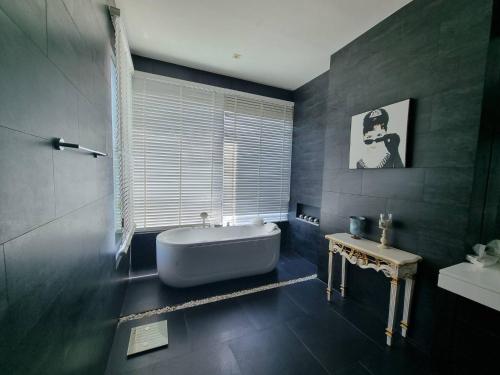 a bathroom with a tub and a window and a sink at Luxury Villa with Panoramic Seaview, Private Pool in Ban Saiyuan (1)