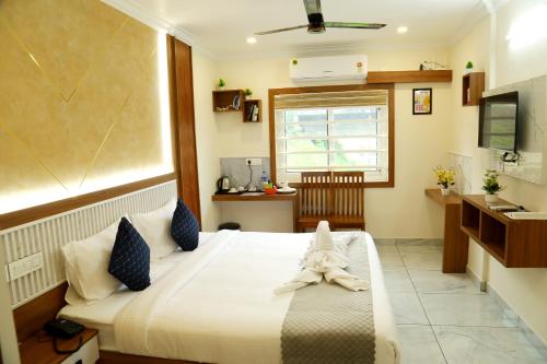 a bedroom with a bed with a towel on it at Cloud9 Airport Hotel in Nedumbassery