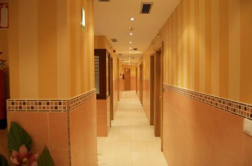 un corridoio in un edificio con pareti in legno e pavimenti piastrellati. di Pension Zorroza 1 a Bilbao