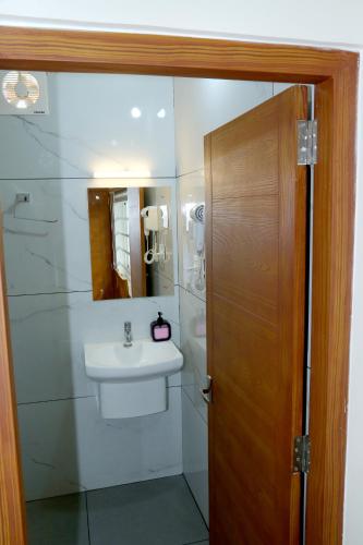 a bathroom with a sink and a toilet and a mirror at Cloud9 Airport Hotel in Nedumbassery