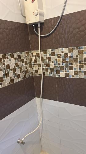 a shower with a shower head in a bathroom at Nahas Beach Resort in Abung