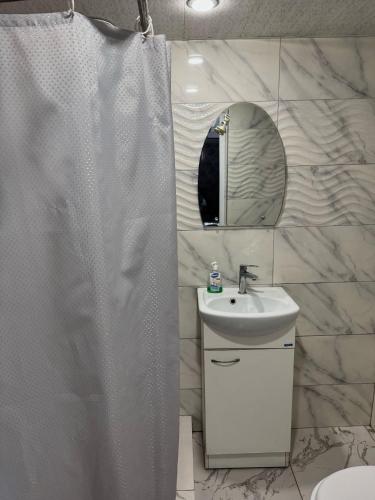 un baño con cortina de ducha y lavabo en Home, en Dilijan