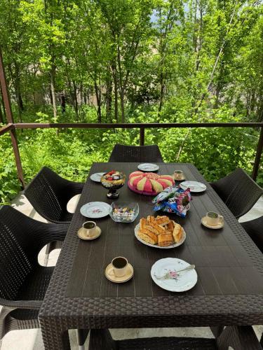 Una mesa de picnic con comida en un balcón. en Home, en Dilijan