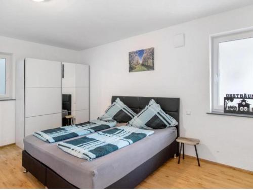 a bedroom with a bed with blue and white pillows at Ferienhof Broger FeWo Obstbäumle mit Pool in Neukirch