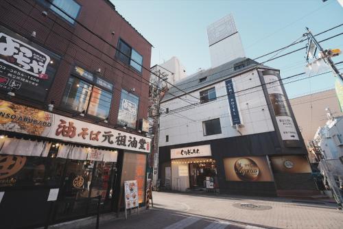 an empty street in an asian city with buildings at Lumi Hotel Tokyo Shinkoiwa JR新小岩駅南口 徒歩1分 in Tokyo