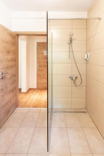 a glass shower in a bathroom with a hallway at Stanglbräu in Hausen