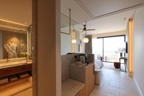 a bathroom with a tub and a sink and a mirror at Gordonia Zikhron Ya'akov in Zikhron Ya'akov