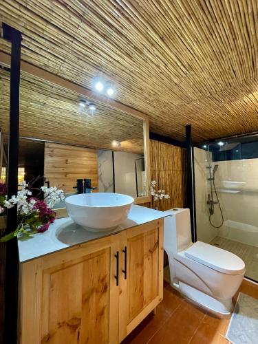 a bathroom with a bowl sink and a toilet at Residence Gratia by Eagle View in Kigali