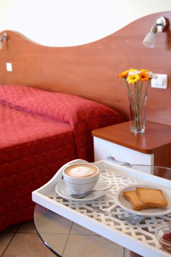 - un plateau avec une tasse de café et du pain sur une table dans l'établissement Motta Residence Hotel, à Motta SantʼAnastasia