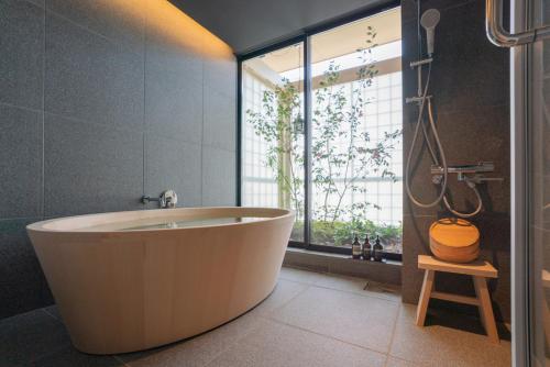 a bath tub in a bathroom with a window at NEW2025! Shirakaba ROKUI 白樺 緑居 Architect-designed Luxury Villa with Concierge Service in Osaka