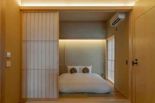 a bedroom with a white bed and a window at NEW2025! Shirakaba ROKUI 白樺 緑居 Architect-designed Luxury Villa with Concierge Service in Osaka