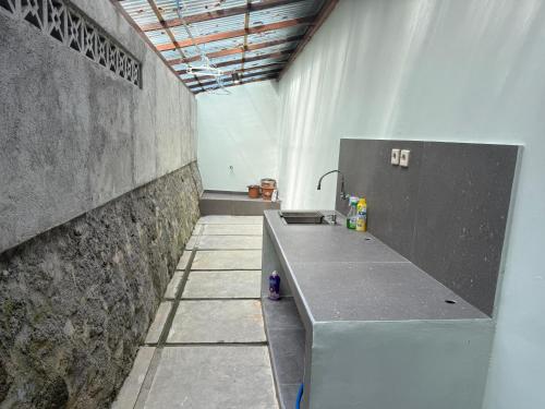 a bathroom with a sink and a concrete wall at Lonovilla Menoreh Yogyakarta in Junggrangan