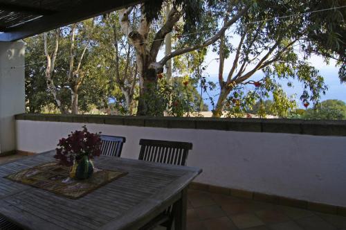 a wooden table with two chairs and a vase of flowers at Villa Alba Appartamenti in Kamma