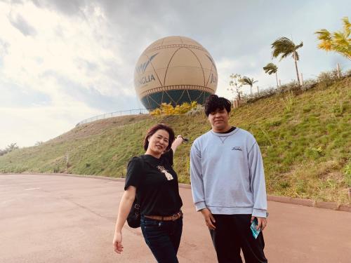 a man and a woman standing in front of a globe at ジャングリアや水族館に近く観光拠点に最適-最大10名 in Nago