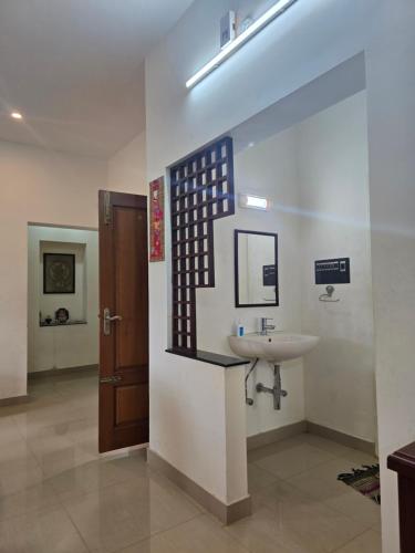 a bathroom with a sink and a mirror at Guru Villa in Yercaud