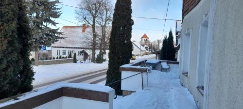 a house with snow on the side of it at Apartament in Rydzewo