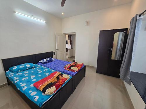 a bedroom with a bed with a blue comforter at Guru Villa in Yercaud