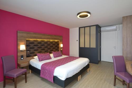 a hotel room with a bed and a chair at The Originals Boutique, Hôtel Le Lion d'Or, Fougères Ouest (Inter-Hotel) in Saint-Brice-en-Coglès