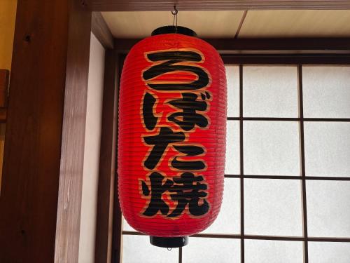 a red chinese light hanging from a ceiling at Yuuzuru in Ito