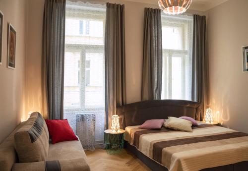 a bedroom with two beds and a couch and a window at Modern Apartment Zlatnicka 8 in Prague