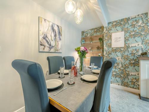 a dining room with a table and blue chairs at Station View in Pickering