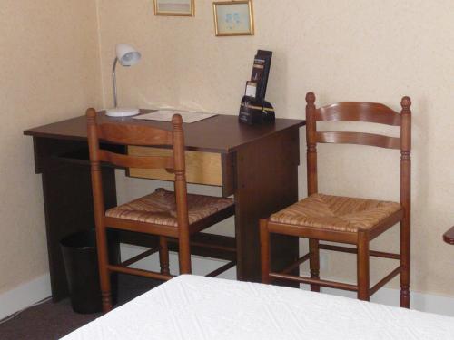 a desk with two wooden chairs and a telephone at Cit'Hotel Aéro-Hotel in Le Blanc-Mesnil