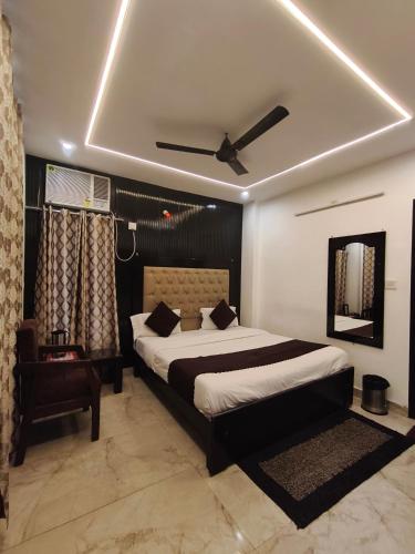 a bedroom with a bed and a ceiling fan at Hotel Gulmohar in Haridwār