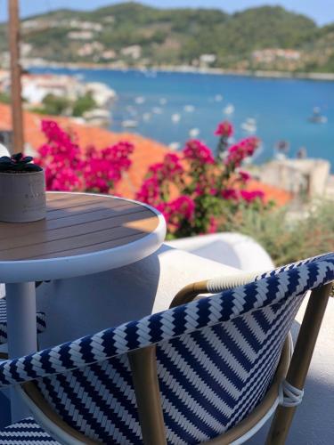 a table and a chair with a table and flowers at Oikies Skiathos in Skiathos