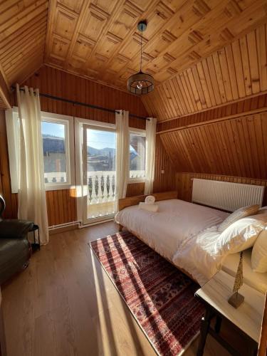 a bedroom with a bed and a large window at Vacation with Purpose in Gura Humorului