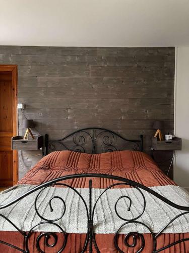 a bedroom with a bed with a wooden wall at Chez Claire et Olivier in Nabringhen