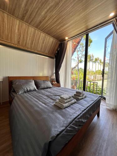a bedroom with a large bed with towels on it at Homestay Mộc An in Lagi