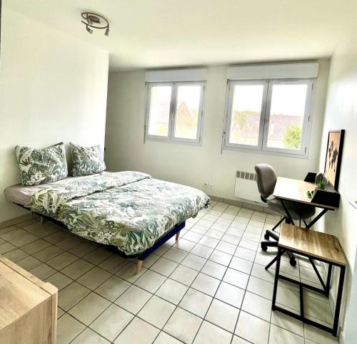 a bedroom with a bed and a desk and two windows at Studio Cosy proche CHU in Amiens