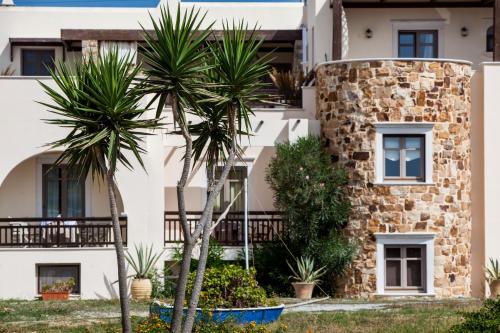 a building with palm trees in front of it at Athina Studios and Suites Plaka in Plaka