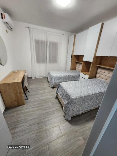 a room with two beds and a desk in it at Albert's house for rent in Vlorë