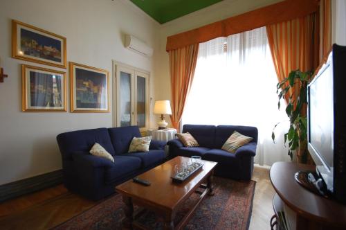 a living room with a blue couch and a coffee table at Hotel Ely in Viareggio