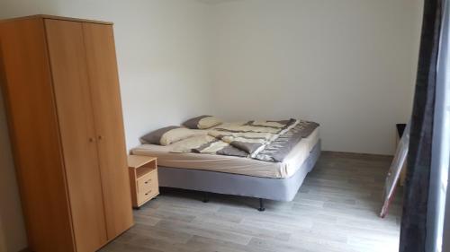 um pequeno quarto com uma cama e uma cómoda em Apartmán u červeného kostela em Teplice