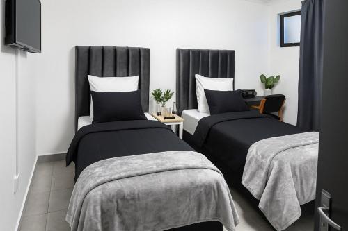 a bedroom with two beds and a table with a tv at AAA Luxury Cottages in Cape Town