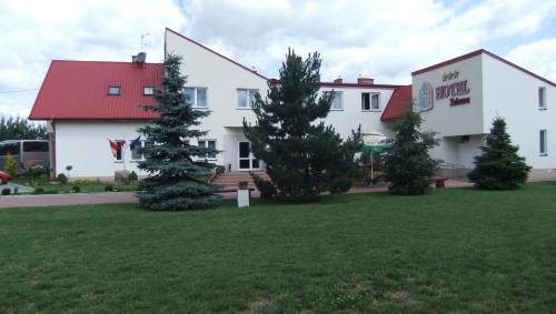a large white building with trees in front of it at Hotel Zabawa in Zabawa