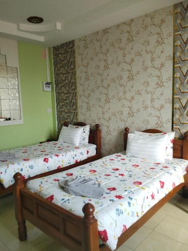 two beds sitting next to each other in a room at บ้านพัก สายรุ้ง in Ban Hua Saphan