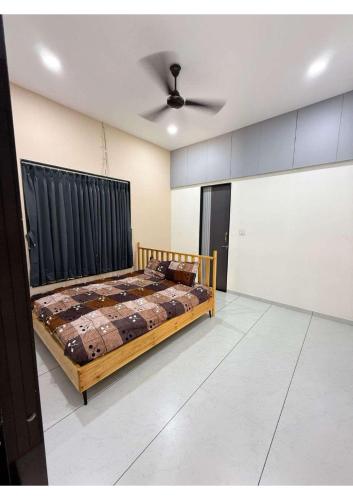 a bedroom with a bed and a ceiling fan at Grey Stone Farm House in Surat