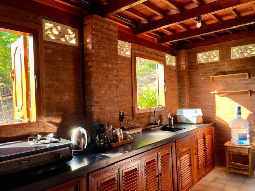 a kitchen with a sink and two windows at Secret Beach Beachfront Villa in Papak