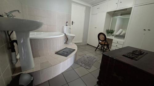 a bathroom with a sink and a bath tub at Oppihoek Gastehuis in Kroonstad