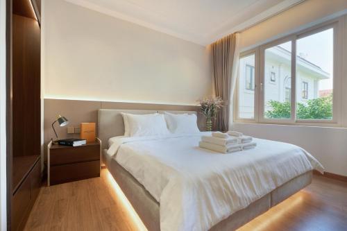 a bedroom with a white bed and a window at HAITA Suites - Phu My Hung in Ho Chi Minh City