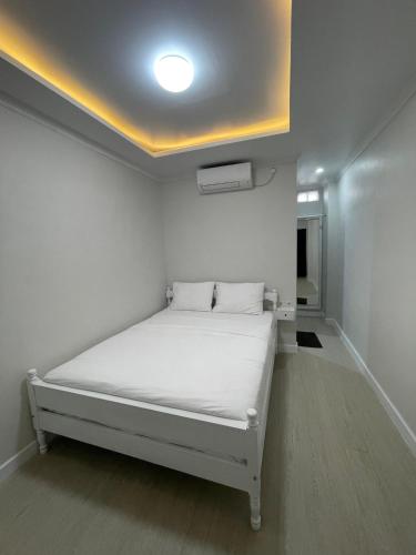 a white room with a bed with a white ceiling at Homestay Harmonie Cepu in Padangan