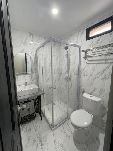 a bathroom with a shower and a toilet and a sink at Homestay Harmonie Cepu in Padangan