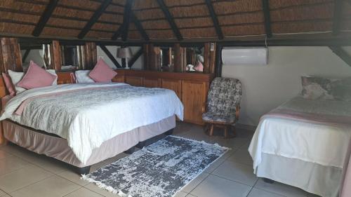 a bedroom with a bed and a chair in a room at Oppihoek Gastehuis in Kroonstad
