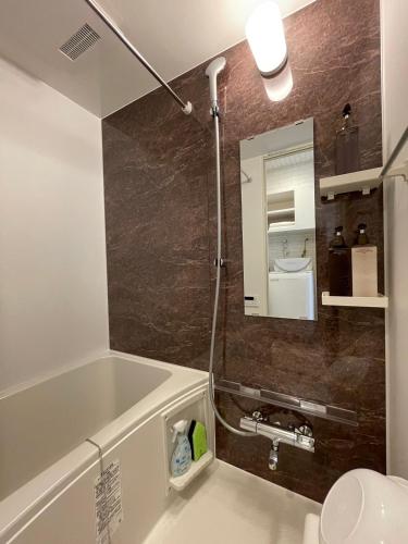 a bathroom with a bath tub and a sink at CRYSTAL & RESORT Exclusive in Fukuoka